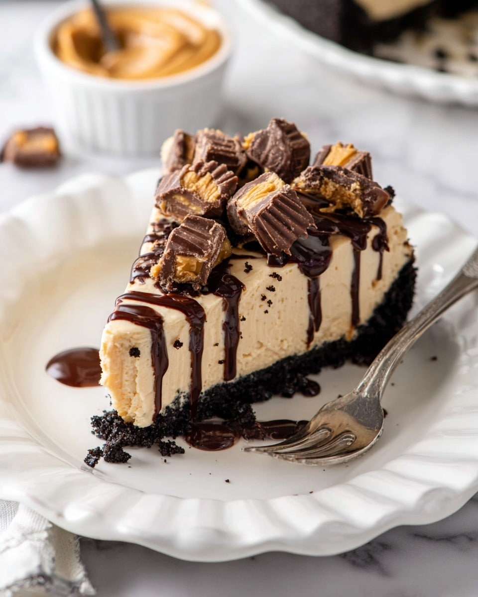 A slice of cheesecake sits on a white scalloped plate over a white marbled surface. The dessert has three layers: a thick dark chocolate crumb crust at the bottom, a smooth creamy beige cheesecake layer in the middle, and on top, large chunks of chocolate peanut butter cups scattered generously. Dark chocolate sauce is drizzled over the top and sides of the slice, pooling slightly on the plate. A silver fork rests beside the cheesecake. In the background, there is a white bowl with peanut butter and a spoon inside. photo taken with an iphone --ar 4:5 --v 7