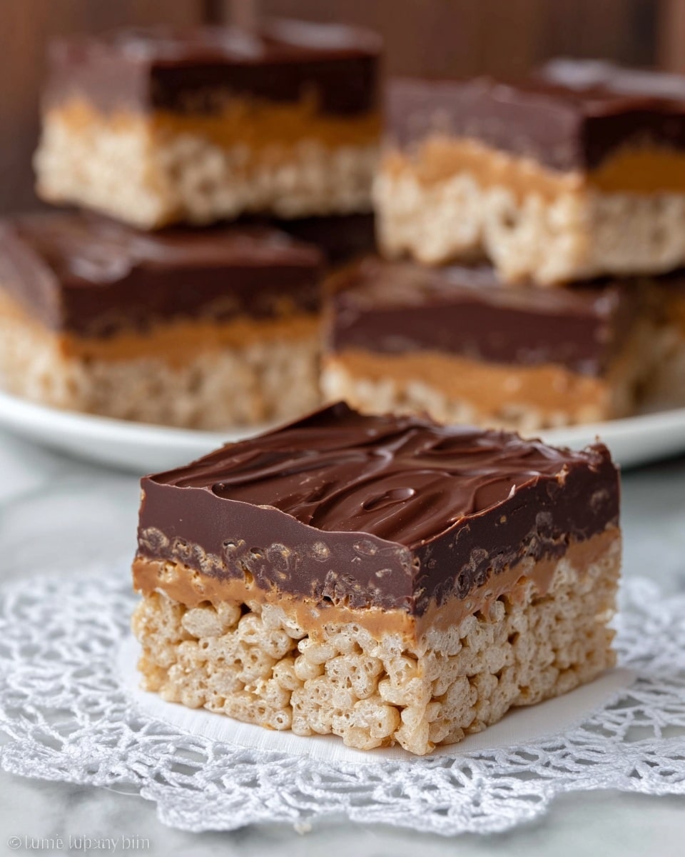 The image shows a square, three-layered dessert bar sitting on a white doily over a white marbled surface. The bottom layer is light beige and crispy, made of puffed rice cereal. The middle layer contains a thick, smooth, peanut butter-colored filling with some hidden swirls of dark chocolate. The top layer is a glossy, rich dark brown chocolate coating with a few subtle texture lines. In the background, more of these bars are stacked, all displaying the same three distinct layers. Photo taken with an iphone --ar 4:5 --v 7