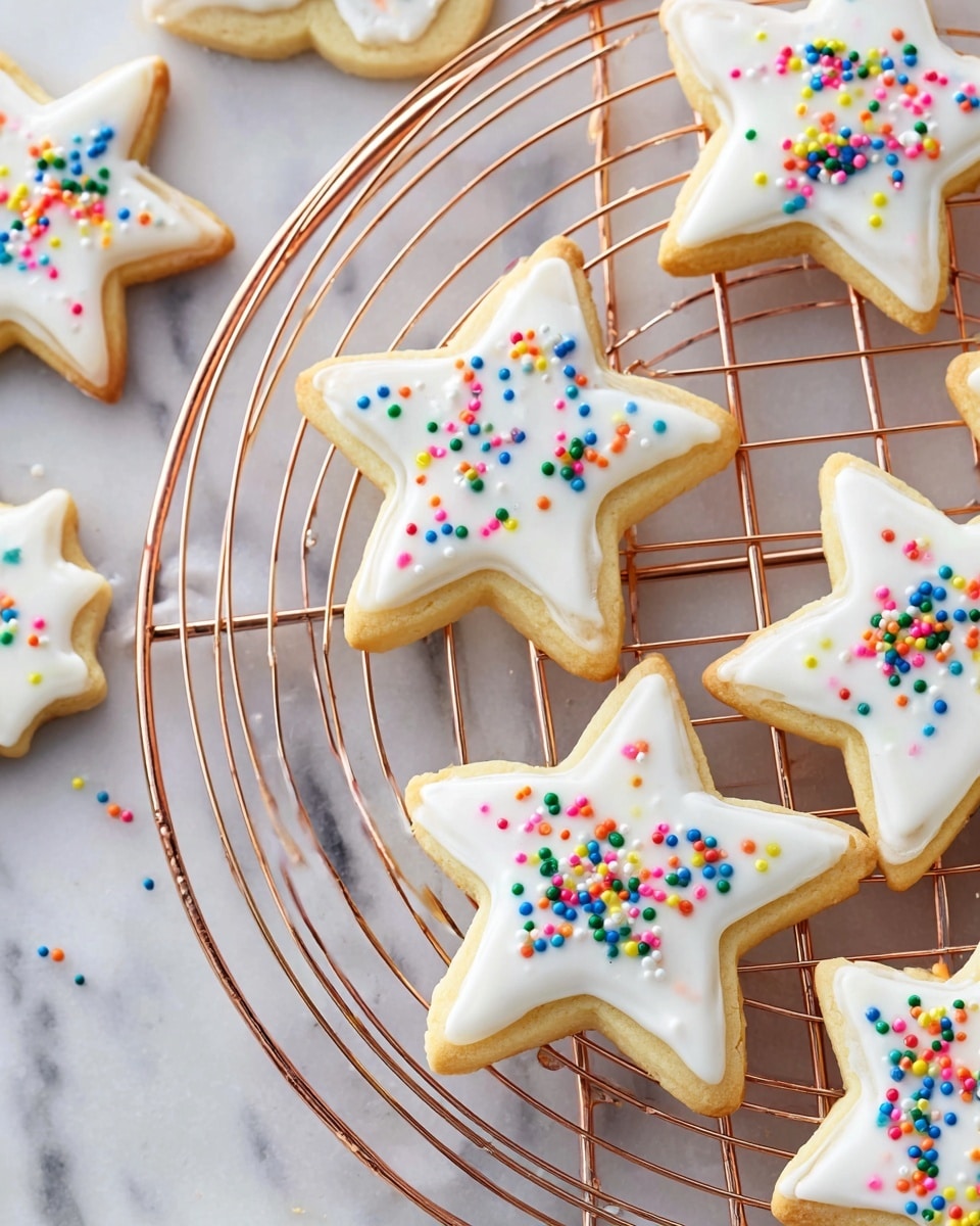 The image shows several star and comet-shaped sugar cookies arranged on two metal cooling racks, one circular and copper-colored and the other rectangular and silver-colored, all placed on a white marbled surface. Each cookie has two visible layers: the base layer is a light golden-yellow baked cookie with a soft texture, and the top layer is a smooth, bright white icing neatly spread over the top surface, following the shapes closely. Colorful small round sprinkles in red, green, blue, yellow, pink, orange, and white are scattered randomly over the white icing, adding a playful and festive touch to the light-colored cookies. Photo taken with an iphone --ar 4:5 --v 7