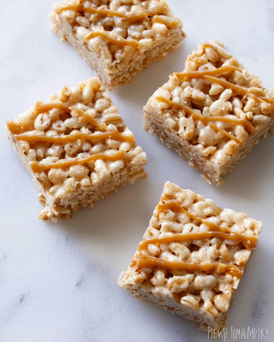 The image shows four square rice crispy treats placed on a white marbled textured surface. Each treat has a light golden color with visible puffed rice pieces, and they are drizzled with a thin layer of glossy caramel sauce on top, adding a rich amber tone. The treats are evenly cut with slightly rough edges, and the texture looks crunchy and chewy. The background is plain and bright, highlighting the dessert’s details clearly. Photo taken with an iphone --ar 4:5 --v 7
